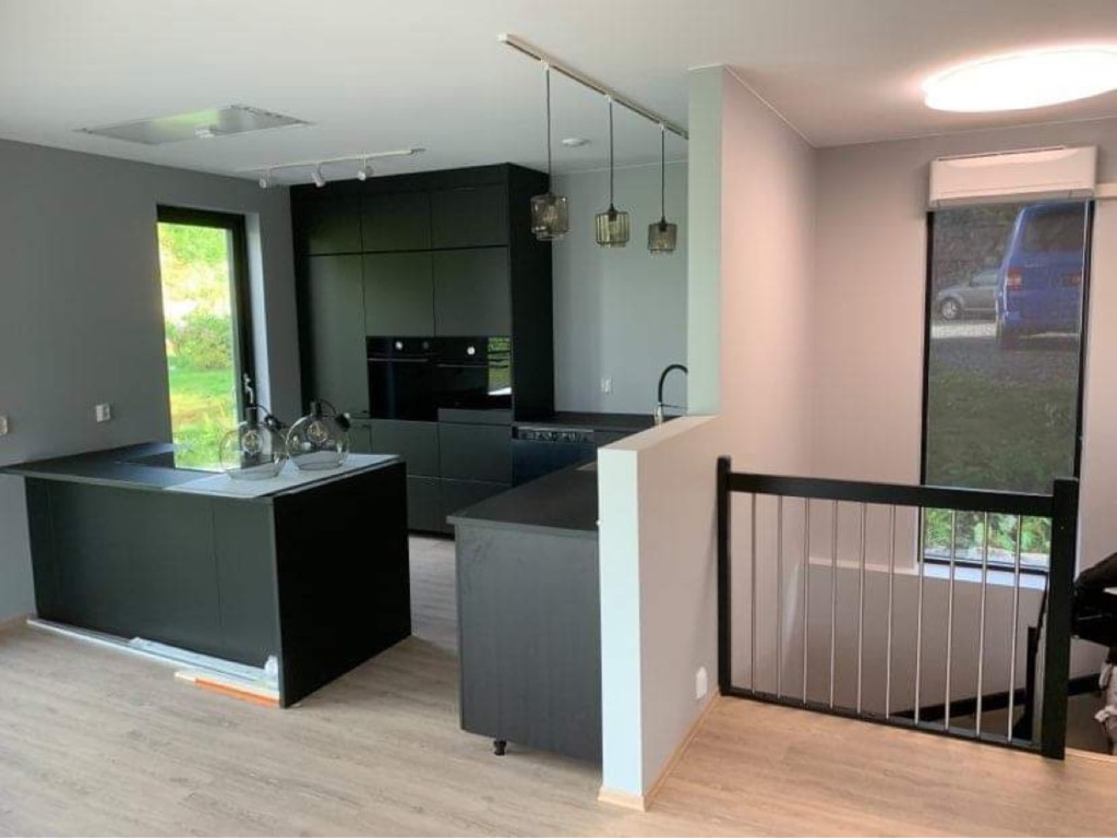 Kjøkken med mørke fronter og kjøkkenøy i Villa Hellesund