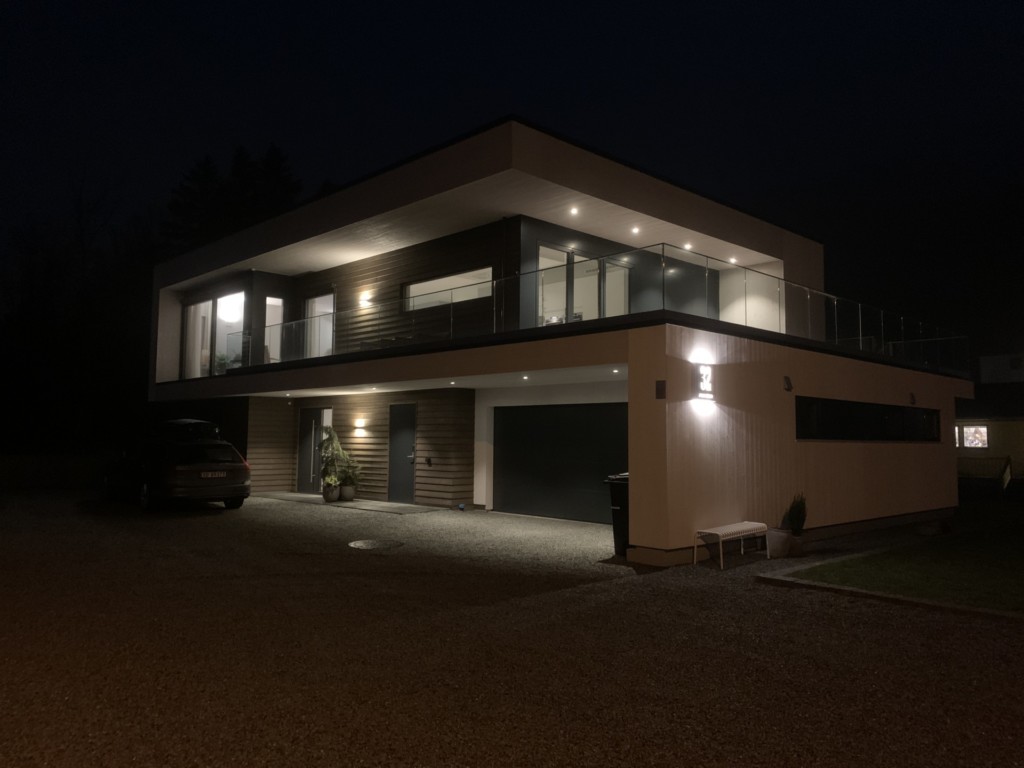 Villa Olsen med fasadebelysning om kvelden