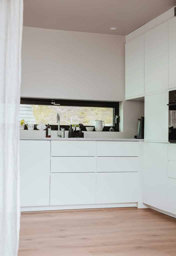 Lyst kjøkken med benkeplate og integrerte hvitevarer