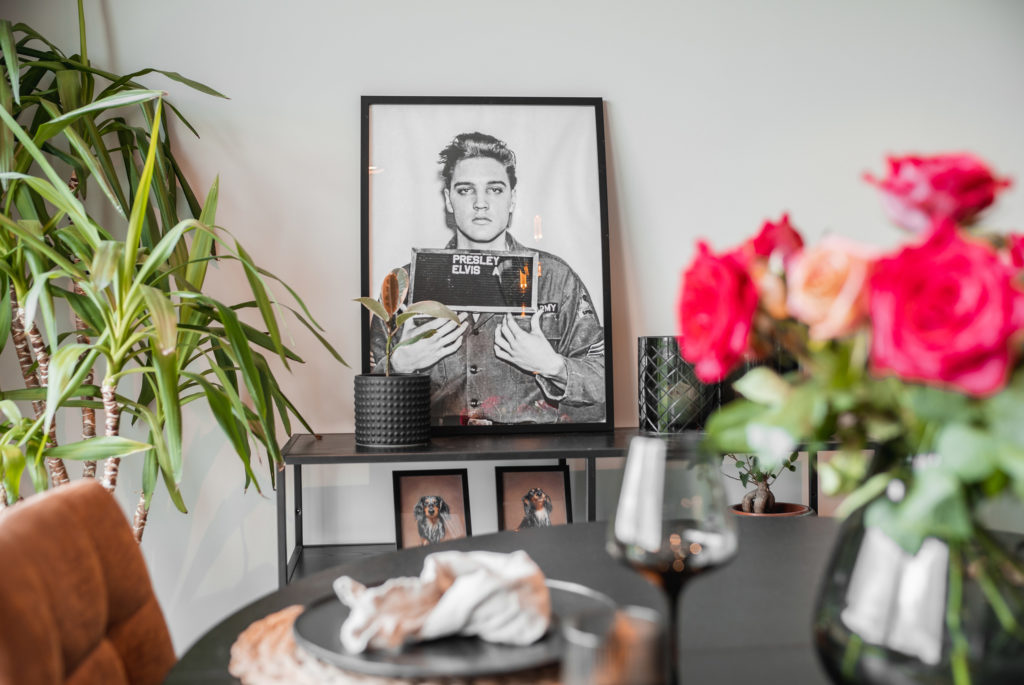 Spiseplass med blomster og innrammet Elvis-portrett